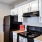 Apartment kitchen with white cabinets and black appliances